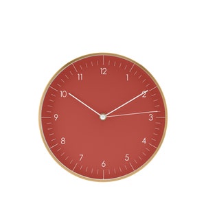 May include: A red analog wall clock with gold trim and white hands. The clock face has white numbers 1 through 12.