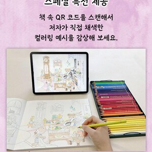 May include: A coloring book page with a drawing of a kitchen scene featuring bears. A hand is holding a yellow colored pencil and coloring the page. A tablet is displaying a colored version of the same image. A box of colored pencils is on the table. The text on the page reads "스페셜 특전 제공 책 속 QR 코드를 스캔해서 저자가 직접 채색한 컬러링 예시를 감상해 보세요. 태블릿 PC에 띄워 놓고 참고해서 색칠할 수도 있어요."