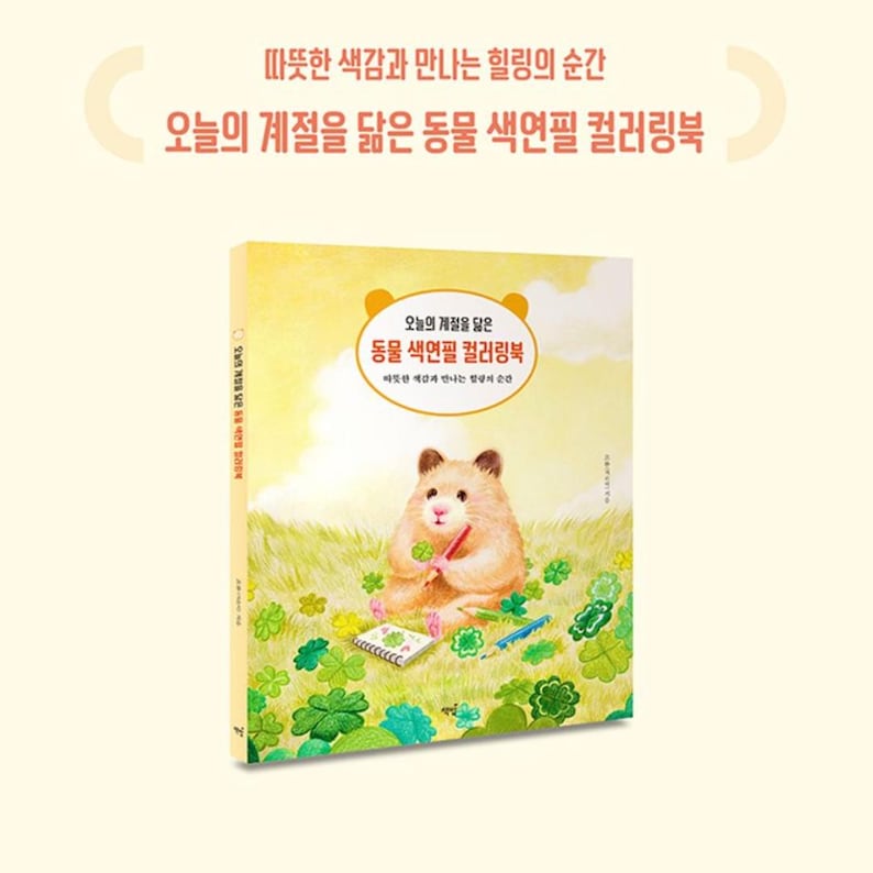 May include: A coloring book cover featuring a hamster sitting on a bed of green clover. The hamster is holding a pencil and a notebook. The title of the book is "오늘의 계절을 닮은 동물 색연필 컬러링북" which translates to "Animal Colored Pencil Coloring Book that Resembles Today's Season".