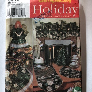 May include: A Simplicity Holiday pattern for a Christmas tree topper, table runner, and mantel decoration. The pattern features a green and white design with a poinsettia motif. The pattern is titled "Noel" and is part of the Simplicity Holiday collection.