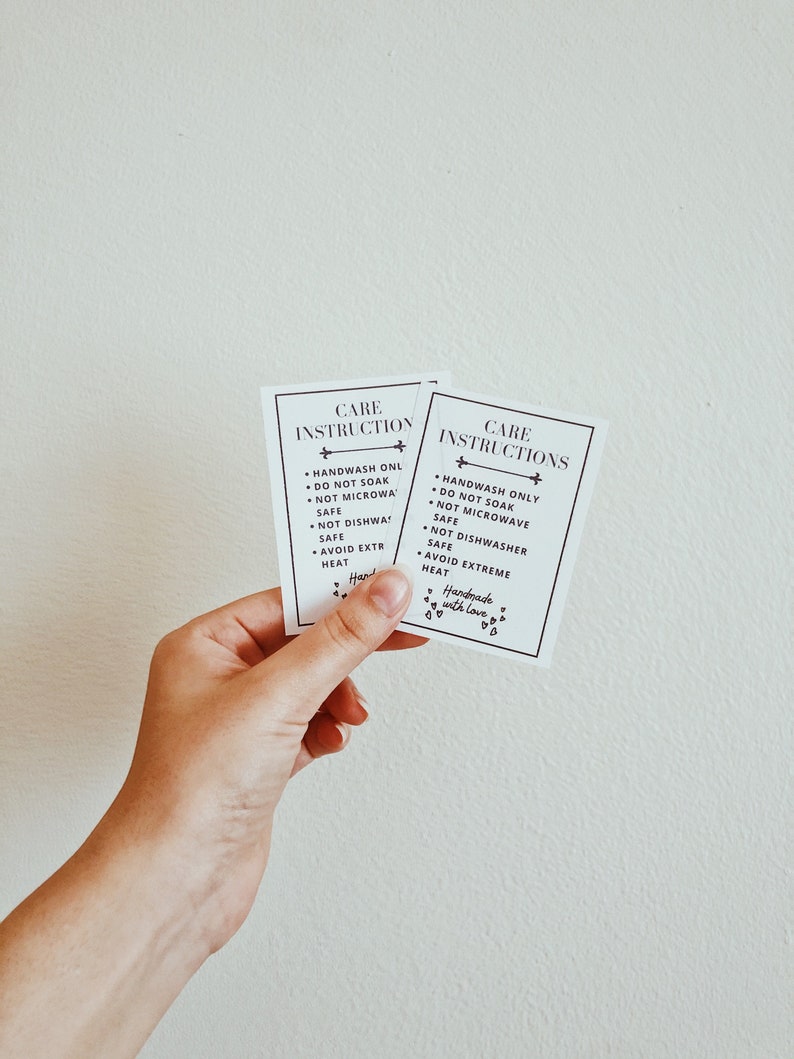 May include: Two rectangular white cards with black text reading CARE INSTRUCTIONS, followed by bullet points: HANDWASH ONLY, DO NOT SOAK, NOT MICROWAVE SAFE, NOT DISHWASHER SAFE, AVOID EXTREME HEAT, and the phrase Handmade with love with small hearts.