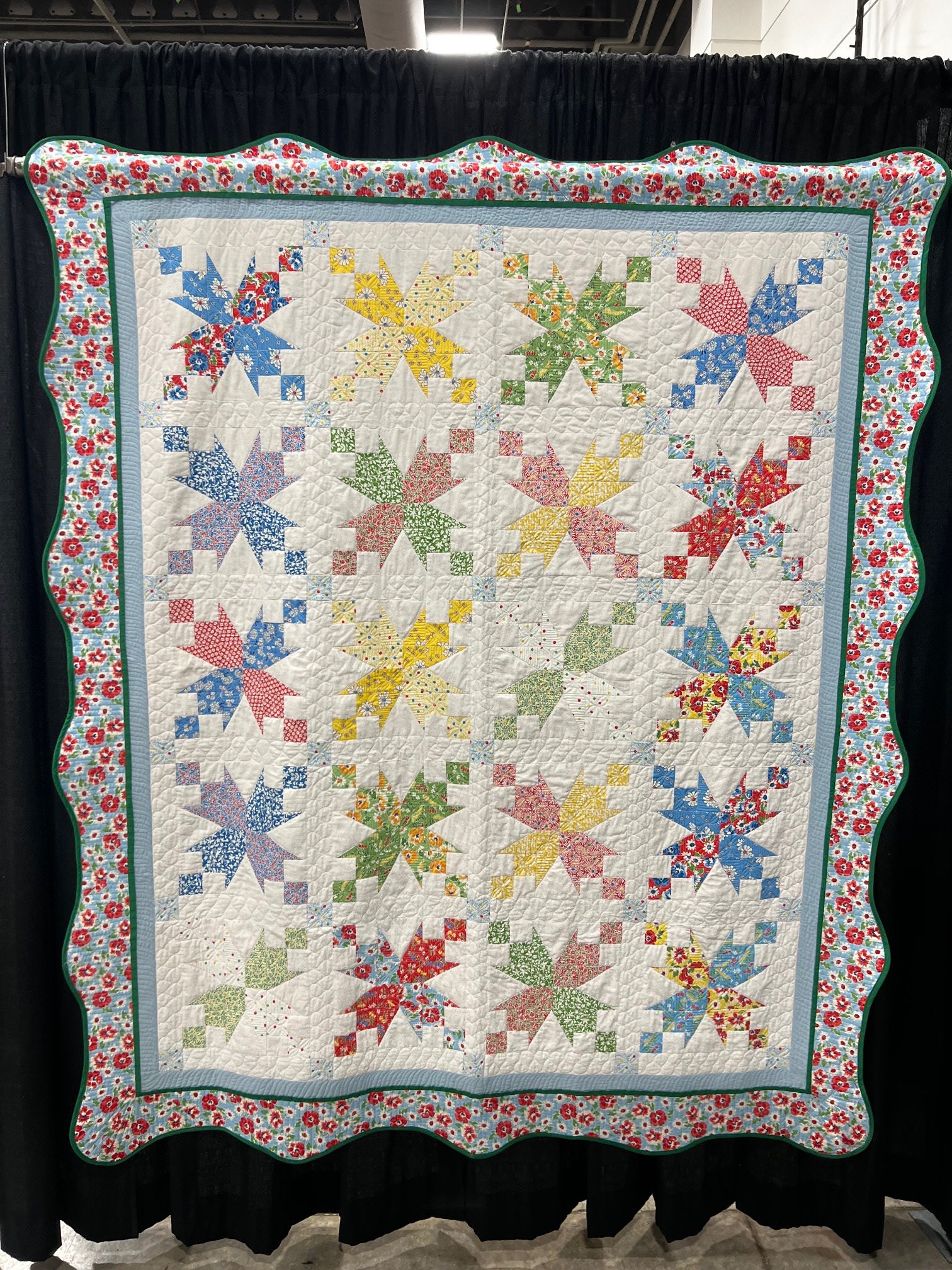Vintage uitziende jaren 1930 reproductiestof Garden Walk quiltblokpatroon met regenboogkleuren geschulpte rand biologische free-motion quilt
