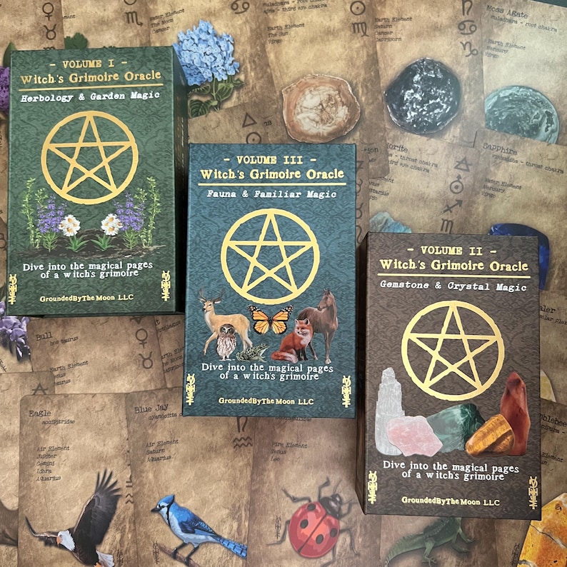 May include: Three oracle card decks titled "Witch's Grimoire Oracle" with different volumes: Herbology & Garden Magic, Fauna & Familiar Magic, and Gemstone & Crystal Magic. Each deck features a gold pentagram design and the text "Dive into the magical pages of a witch's grimoire."