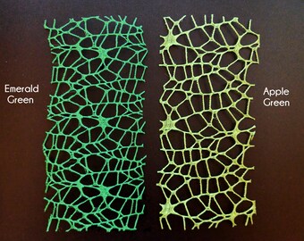 May include: Two pieces of green lace fabric, one emerald green and one apple green. The lace has a web-like pattern.