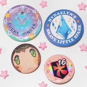 May include: Four colourful round badges with illustrations and text. One badge says "LUCKY WINNER" with a bunny illustration. Another says "HYDAELYN'S BRAVE LITTLE SPARK". The other two badges have character art and the number "16". Pink star-shaped decorations surround the badges.