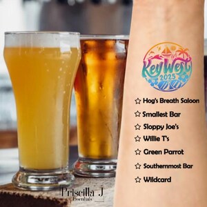 May include: A temporary tattoo with a colorful Key West 2025 logo and a list of bars to visit: Hog's Breath Saloon, Smallest Bar, Sloppy Joe's, Willie T's, Green Parrot, Southernmost Bar, and Wildcard.