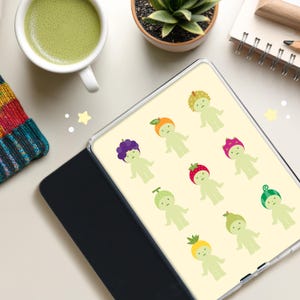 Könnte beinhalten: Eine Tablet-Hülle mit einem sich wiederholenden Muster von Cartoonfiguren mit Obst-Themen-Hüten. Die Figuren sind hellgrün mit Hüten wie Trauben, Erdbeeren und Orangen. Die Hülle ist offen und zeigt den Bildschirm mit dem Design.