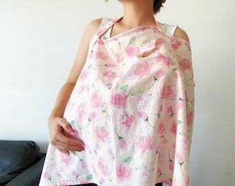 May include: A pink and white floral nursing cover with a delicate watercolor design. The cover is made of a soft, breathable fabric and features a comfortable, adjustable strap.
