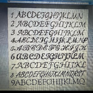 May include: A close-up of a grid with nine rows of the alphabet in a cursive font. Each row displays a different style of the alphabet, with variations in letter shapes and spacing. The letters are dark against a light background.