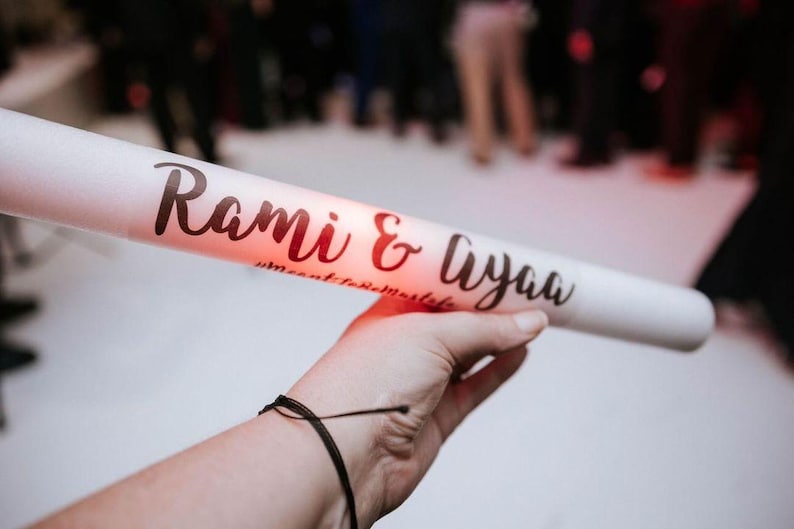 May include: White foam tube with the text "Rami & Liyaa" in black script. The tube is lit from inside with a red glow.