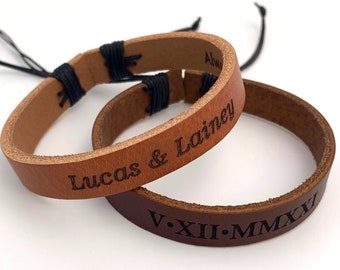 May include: Two brown leather bracelets with black string closures. One bracelet is engraved with "Lucas & Lainy" and the other with "V.XII.MMXI".