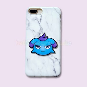 Op de afbeelding: Telefoonhoesje met een wit marmerpatroon, versierd met een cartoonfiguur met een blauw lichaam, paarse oren en een serieuze uitdrukking. De hoes is ontworpen voor een smartphone en heeft een glanzende afwerking.