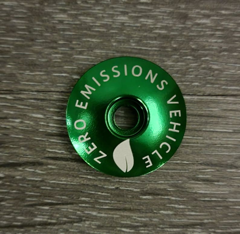 May include: Green metal bicycle stem cap with the text "ZERO EMISSIONS VEHICLE" and a leaf design.