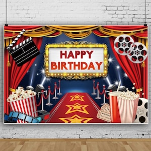 Puede incluir: Un telón de fondo festivo de cumpleaños con una alfombra roja con estrellas doradas, un letrero que dice "HAPPY BIRTHAY" y elementos temáticos de películas como palomitas de maíz, carretes de película y una claqueta. El fondo tiene cortinas rojas y focos.