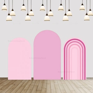 Puede incluir: Dos fondos de arco rosa para fotografía. Un fondo es rosa sólido y el otro tiene un diseño de arcoíris rosa degradado.