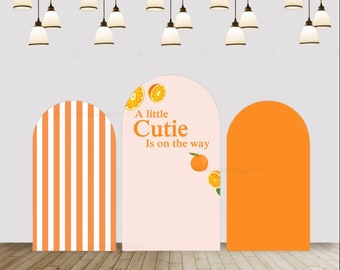 May include: Orange and white striped backdrop with a pink backdrop that says "A little Cutie Is on the way" with orange slices and leaves. There is also a solid orange backdrop.