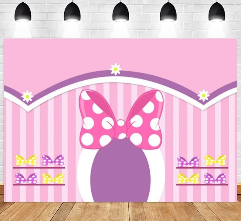 K&ouml;nnte beinhalten: Rosa-lila gestreifter Hintergrund mit einer gro&szlig;en rosa Schleife mit wei&szlig;en Punkten. Die Schleife befindet sich auf einem lila Kreis mit wei&szlig;em Rand. Es gibt drei Reihen kleinerer Schleifen in rosa, gelb und lila.