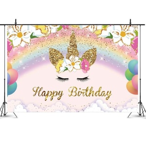 May include: A pink and purple unicorn backdrop with a rainbow, gold glitter, and the words "Happy Birthday".