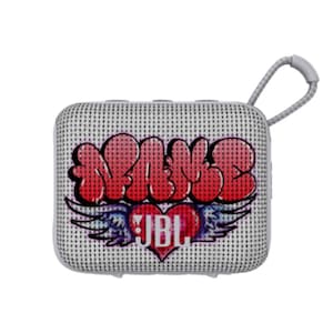 May include: A square, portable JBL speaker with a white perforated surface. The speaker features red graffiti-style text that reads "BABE" above a heart with wings and the JBL logo. A gray loop is attached for carrying.