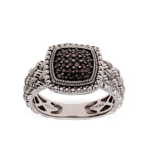 May include: A silver ring with a square, dark red gemstone center. The gemstone is surrounded by a beaded border and set in a square frame. The band has a woven design. The ring is marked "925 JS" and "CHINA".