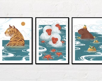 May include: Set of three framed art prints featuring illustrations of animals in water. One print shows a tiger, another depicts snow monkeys, and the third features a capybara. The art has a Japanese aesthetic with a blue and white color scheme.