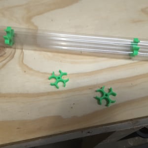 May include: Three green plastic connectors for a clear plastic tube. The connectors are shaped like a star with five points.