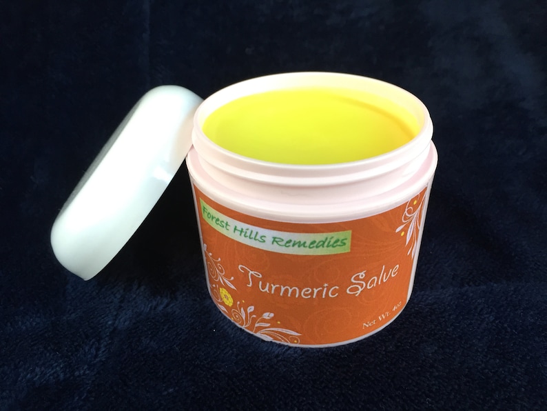 K&ouml;nnte beinhalten: Ein kleines, wei&szlig;es Glas mit einem gelben Deckel. Das Glas enth&auml;lt eine gelbe Salbe und tr&auml;gt ein Etikett mit der Aufschrift "Forest Hills Remedies Turmeric Salve Net Wt 4 oz."