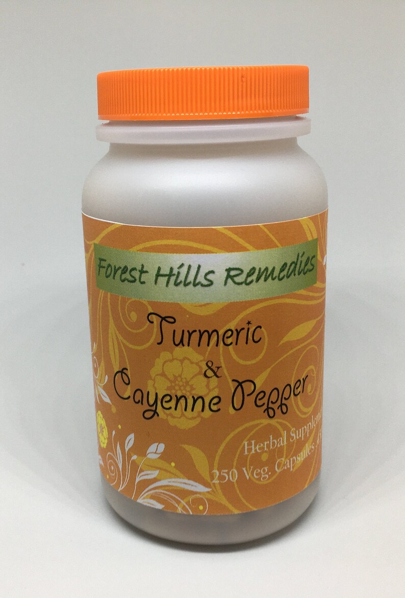 May include: A white plastic bottle with an orange lid, labeled "Forest Hills Remedies Turmeric & Cayenne Pepper Herbal Supplement 250 Veg. Capsules". The label has a yellow and orange background with a floral design.
