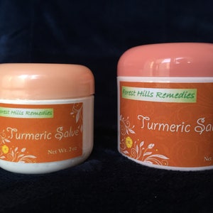 K&ouml;nnte beinhalten: Zwei Gl&auml;ser mit Kurkuma-Salbe, eines mit 2 oz und das andere mit 4 oz. Beide Gl&auml;ser haben einen pfirsichfarbenen Deckel und ein Etikett mit dem Text "Forest Hills Remedies" und "Turmeric Salve".