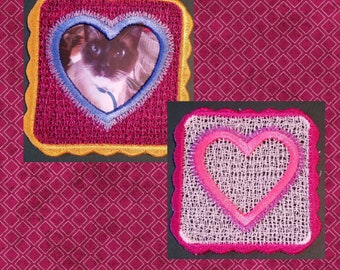 May include: Two free-standing lace heart embroidery designs. The first design is a square with a heart-shaped cutout and a cat photo inside. The second design is a square with a pink heart-shaped cutout. Both designs have a scalloped edge. "Free Standing Lace Hearts #4" is written below the designs.