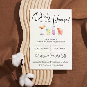 May include: White card with black text that reads "Drinks are on the House!" with a watercolor illustration of four cocktails. The card also includes the text "You're invited to Victoria and Brian's Housewarming!" with the date and time of the event, the address, and an RSVP phone number.