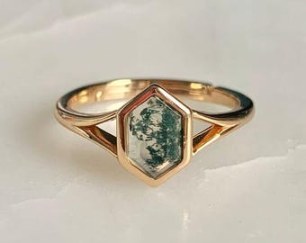 Puede incluir: Un anillo de oro con una piedra de ágata musgosa de forma hexagonal.