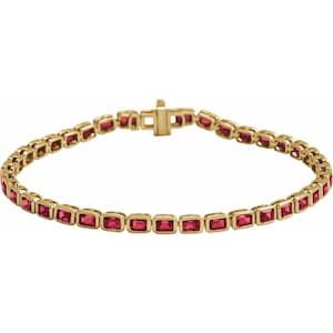 May include: A gold-toned bracelet featuring rectangular red gemstones. The bracelet has a secure clasp and is designed with a continuous pattern of gemstones set in a gold metal frame. The gemstones are a vibrant red color.