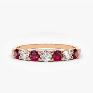 May include: A rose gold band ring with alternating ruby and diamond stones.