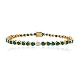 May include: A gold bracelet with emerald-green, teardrop-shaped gemstones. A single white diamond teardrop is set in the centre. The bracelet is secured with a gold clasp.