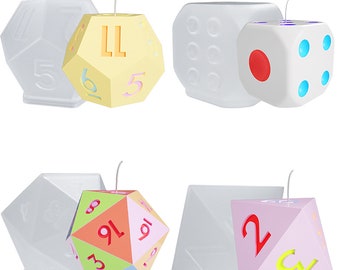 May include: Four different candle molds in the shape of dice. The molds are white and have a clear plastic insert. The dice are in different colors and have numbers on them. The dice are yellow, white, pink, and orange.
