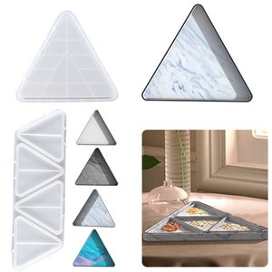 Peut inclure: Ensemble de plateaux et moules triangulaires. Certains plateaux présentent un motif marbré gris et bleu. Un moule transparent révèle les divisions internes. Les plateaux sont divisés en sections.