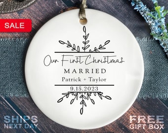May include: White ceramic ornament with a black snowflake design. The ornament says "Our First Christmas Married Patrick + Taylor 9.15.2023"
