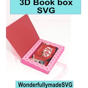 Puede incluir: Una caja de libro 3D rosa con un patrón de lunares y una barra de chocolate roja en su interior. La caja está abierta y la tapa está levantada. El texto "WonderfullymadeSVG" está en la parte inferior de la imagen.