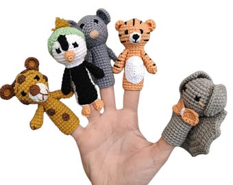 Könnte beinhalten: Satz mit fünf Fingerpuppen mit Tierfiguren. Die Puppen sind gehäkelt und beinhalten einen Pinguin, einen Tiger, einen Koala, einen Leoparden und einen Elefanten. Die Puppen sind alle in verschiedenen Farben und haben unterschiedliche Gesichtsausdrücke.