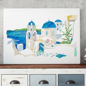 K&ouml;nnte beinhalten: Ein Aquarellbild eines wei&szlig;en Geb&auml;udes mit blauen Kuppeln und einem Glockenturm, vor dem Hintergrund eines blauen Meeres und eines gr&uuml;nen H&uuml;gels. Das Geb&auml;ude ist von wei&szlig;en Mauern und einem gepflasterten Weg umgeben.