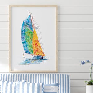 May include: A framed watercolor painting of a sailboat with a colorful, geometric sail. The sail is a mix of blue, green, yellow, and orange. The sailboat is sailing on a white background.