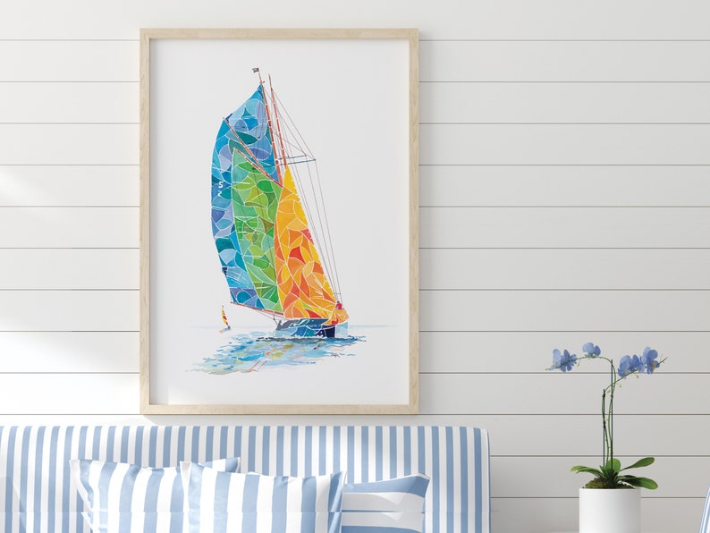 May include: A framed watercolor painting of a sailboat with a colorful, geometric sail. The sail is a mix of blue, green, yellow, and orange. The sailboat is sailing on a white background.