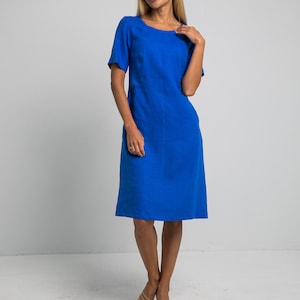 May include: A royal blue linen dress with a scoop neck and short sleeves. The dress is knee-length and has a straight silhouette.