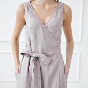 May include: A light gray linen wrap dress with a V-neckline and a self-tie belt.