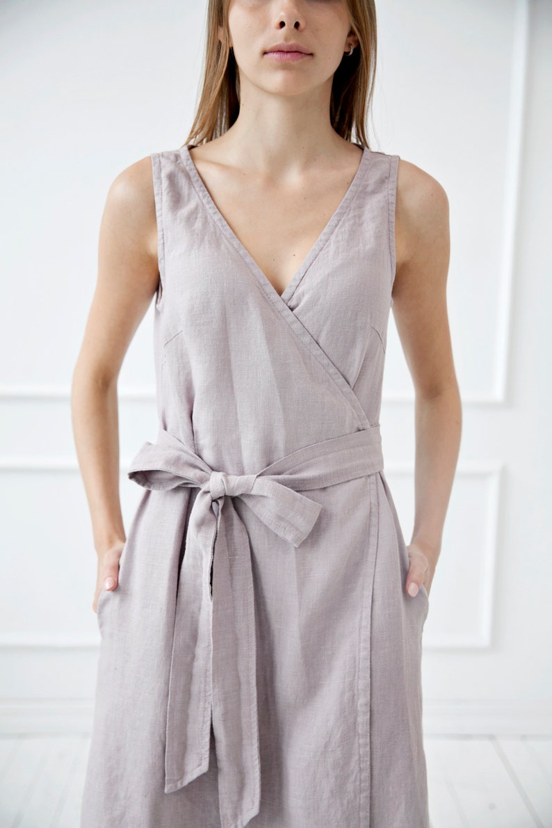 May include: A light gray linen wrap dress with a V-neckline and a self-tie belt.