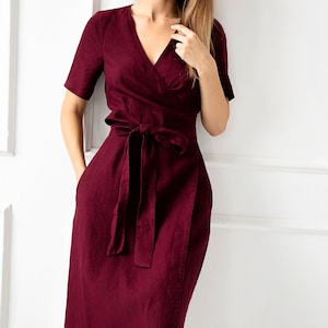May include: A burgundy linen wrap dress with a V-neckline and a tie belt.