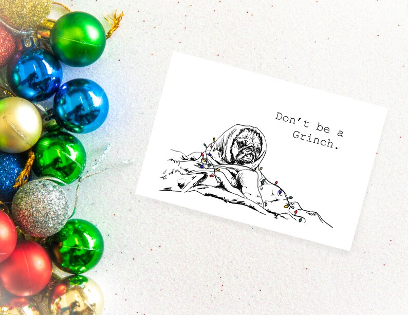 May include: A black and white illustration of a dog wrapped in Christmas lights with the text "Don't be a Grinch."