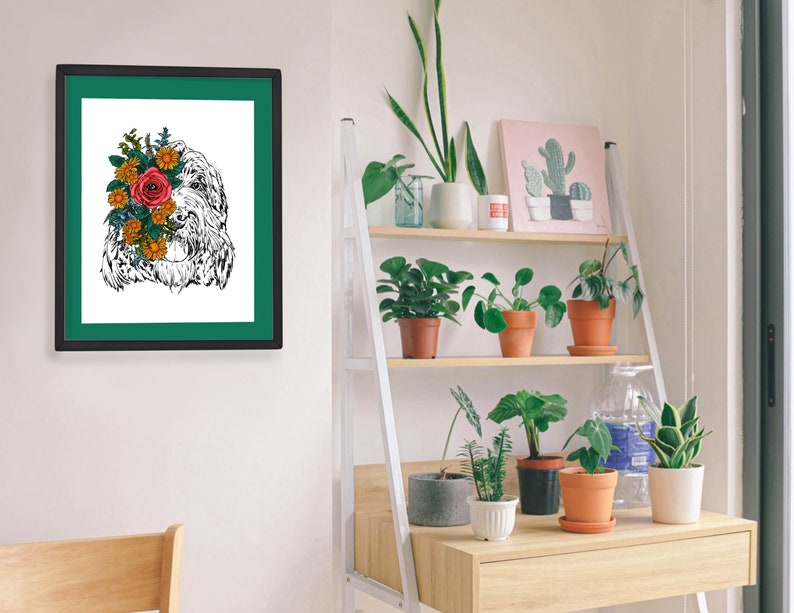 May include: A black and white illustration of a dog with a bouquet of flowers covering its face. The illustration is framed in a black frame with a green mat. The frame is hanging on a white wall.