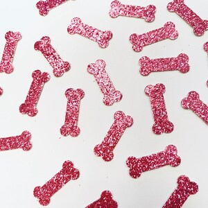 May include: Pink glitter confetti shaped like dog bones.